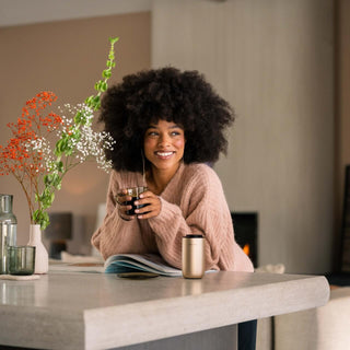 Women holding coffee while aroma diffuser stands in the front